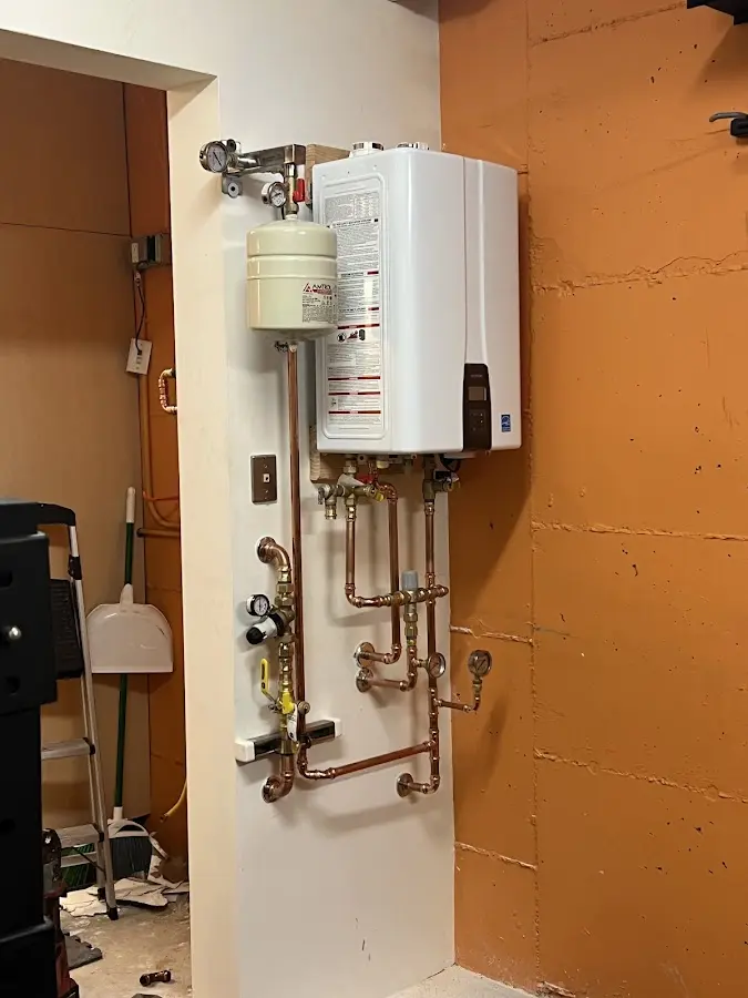 Plumbing technician inspecting water heater connections in Buffalo